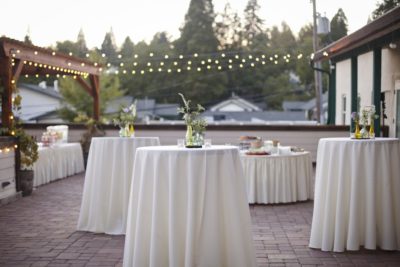 Belly bar tables with round linen cloths.
